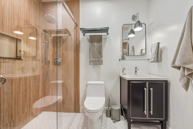 a bathroom with a sink a toilet and shower
