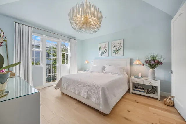 a bedroom with a large bed and a chandelier