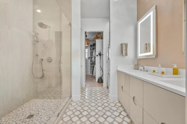 a bathroom with a granite countertop shower a sink and a mirror