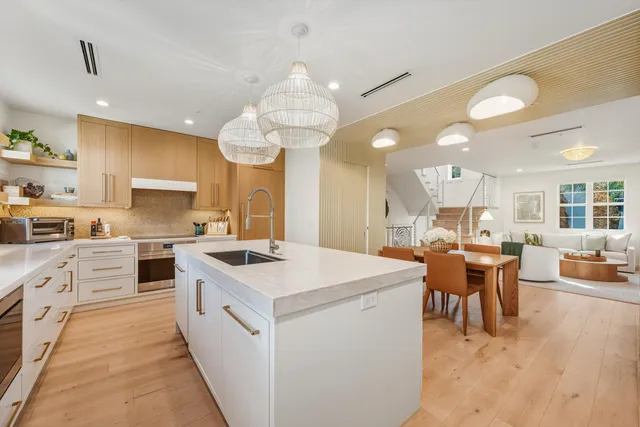 a kitchen that has a lot of cabinets in it and wooden floors