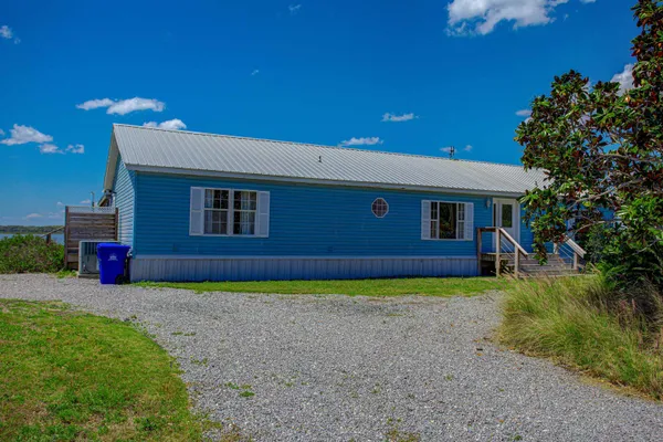 a view of a house with a patio and a yard