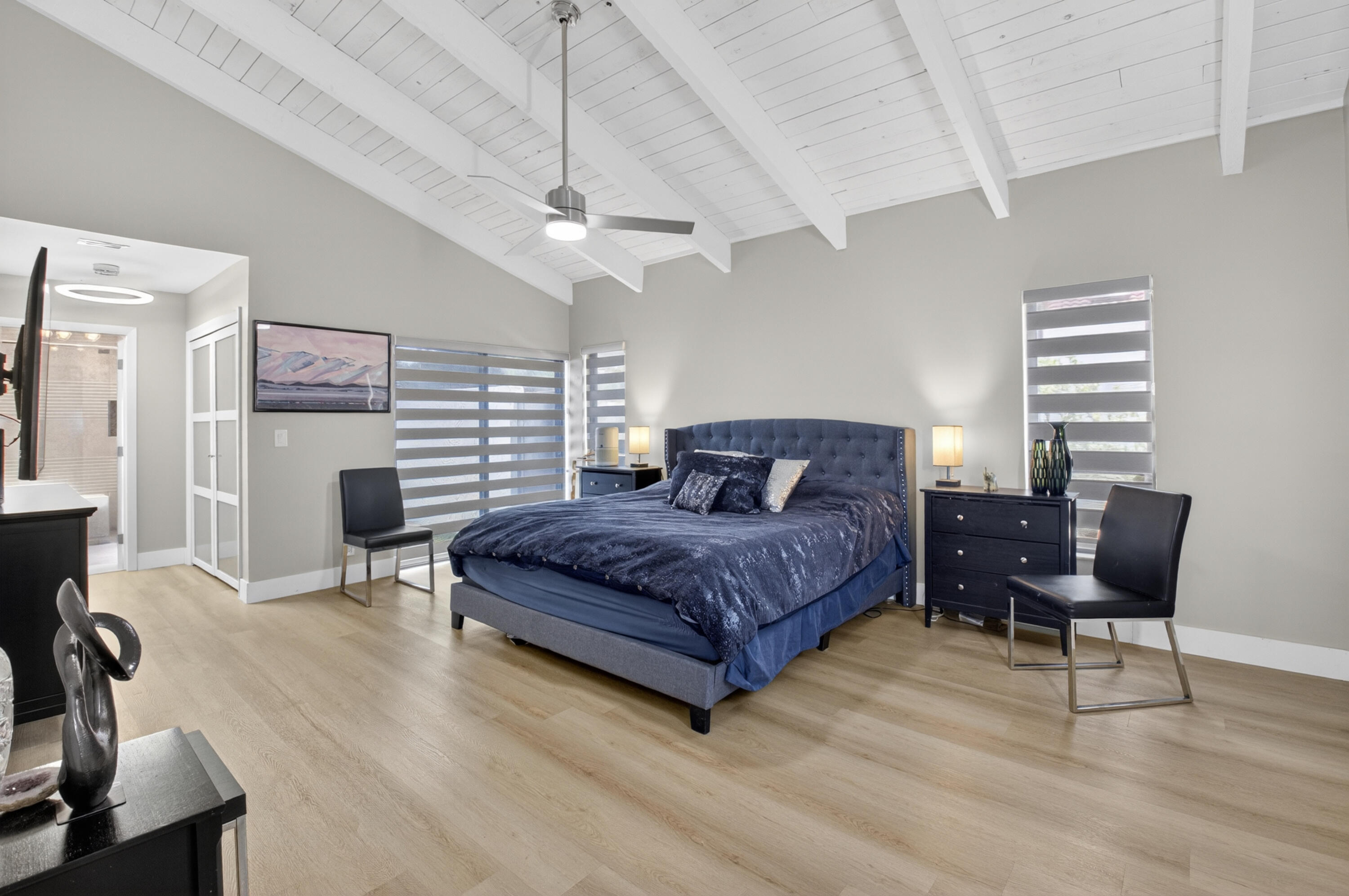 7374 Woodmont Court Boca Raton, FL 33434 - Photo 25 of 95 a spacious bedroom with a bed a chair and a chandelier
