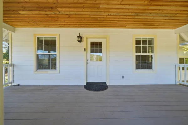 a living room with stainless steel appliances kitchen island granite countertop a sink a stove and a wooden floors