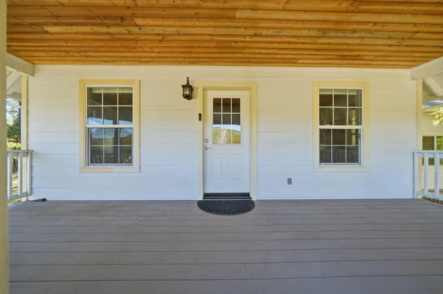 a living room with stainless steel appliances kitchen island granite countertop a sink a stove and a wooden floors