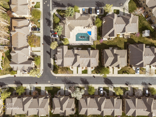 6761 950 East Midvale, UT 84047 - Photo 43 of 44 Aerial view of a residential community featuring a central swimming pool with water features, surrounded by multiple residential structures