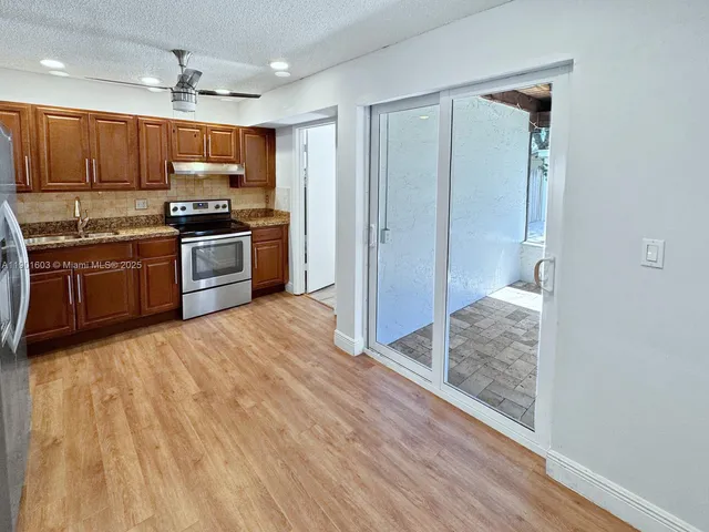 a kitchen with granite countertop a refrigerator and a sink