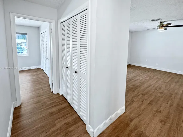 a view of a hallway with wooden floor