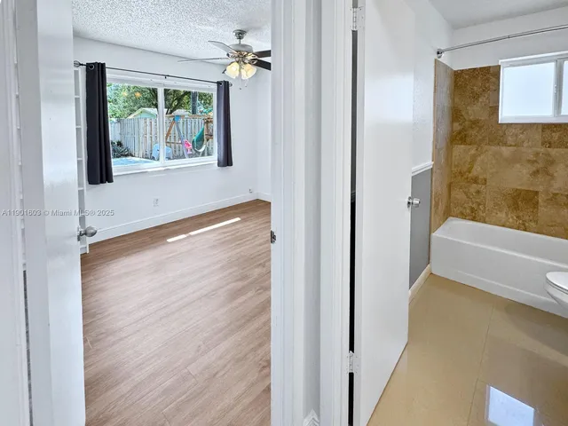 a view of a bedroom with wooden floor and windows