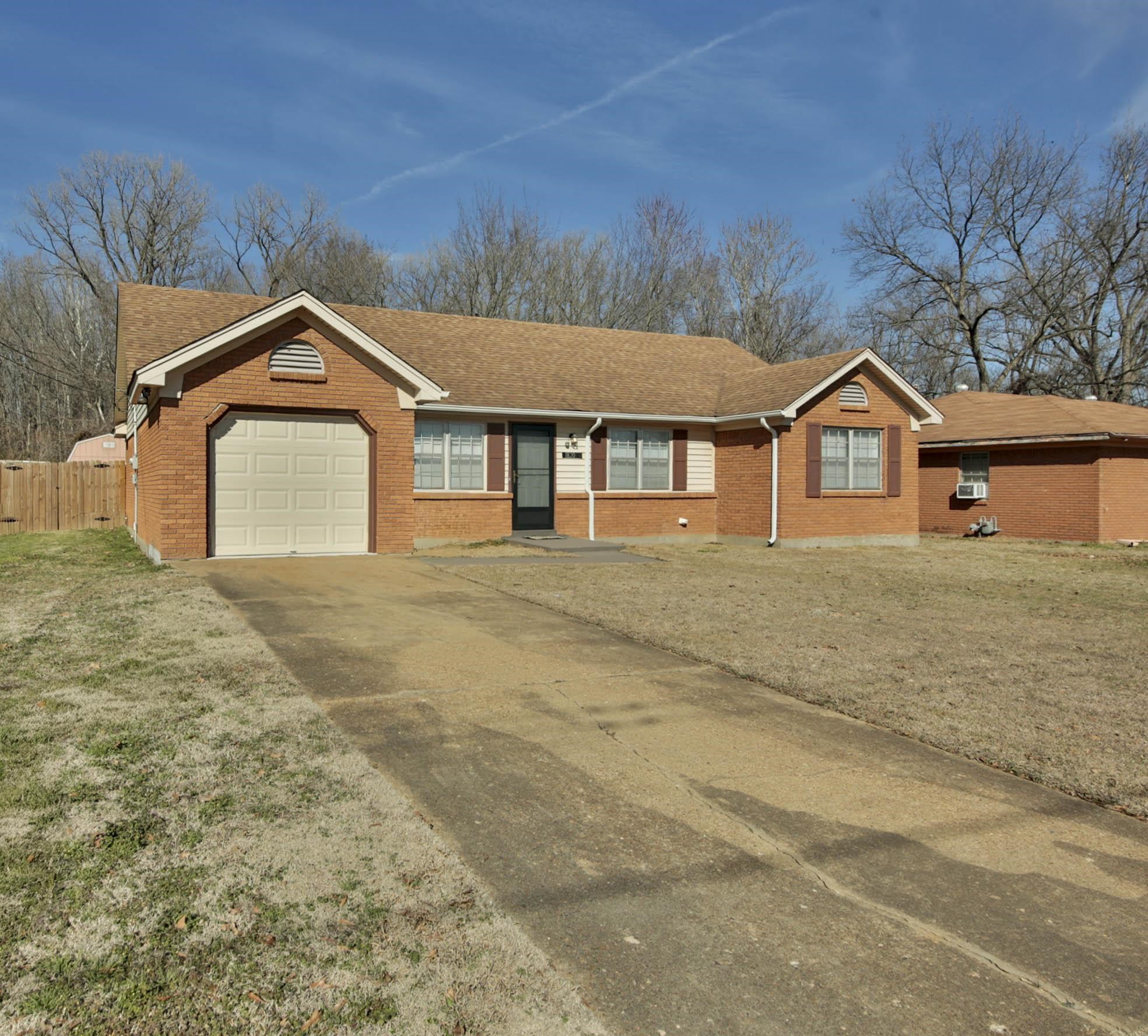 1820 West Holmes Road Memphis, TN 38109 - Photo 1 of 28 Ranch-style home featuring a shingled roof, brick siding, driveway, and an attached garage