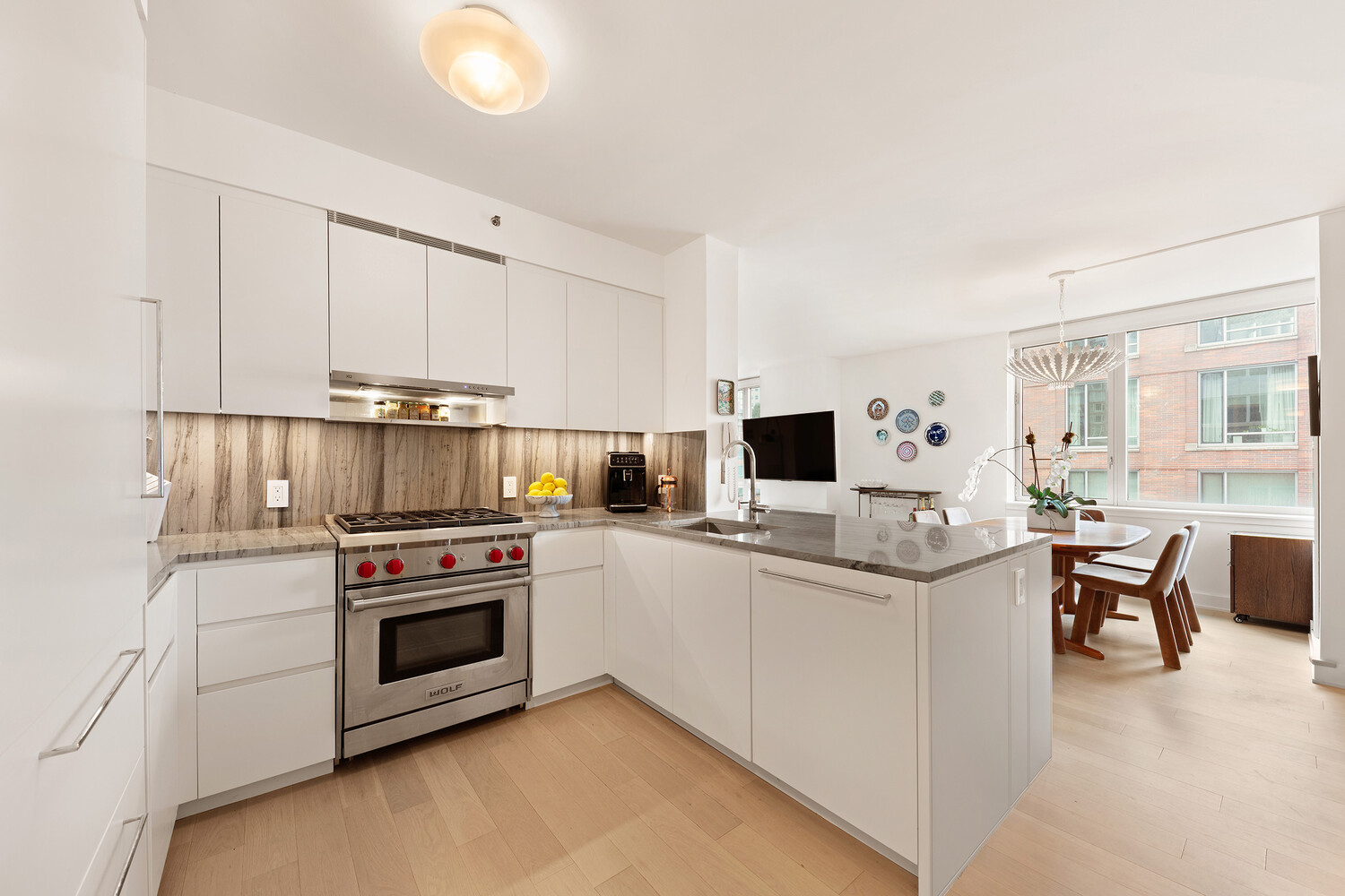 20 River Terrace, Unit 16N Manhattan, NY 10282 - Photo 2 of 9 a kitchen with white cabinets and appliances