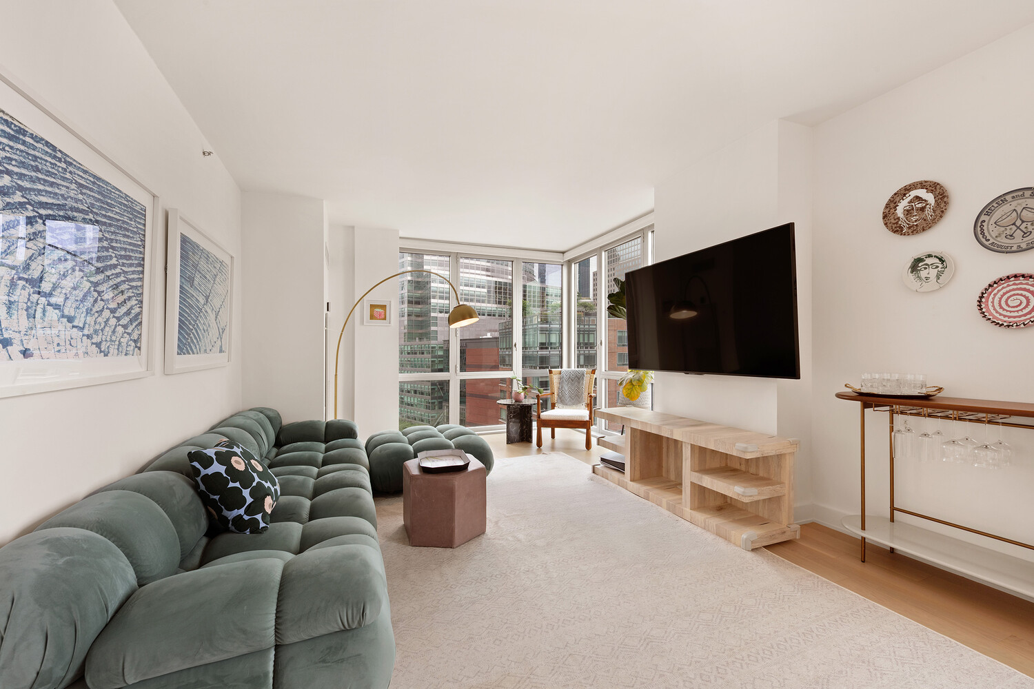 20 River Terrace, Unit 16N Manhattan, NY 10282 - Photo 5 of 9 a living room with furniture and a flat screen tv