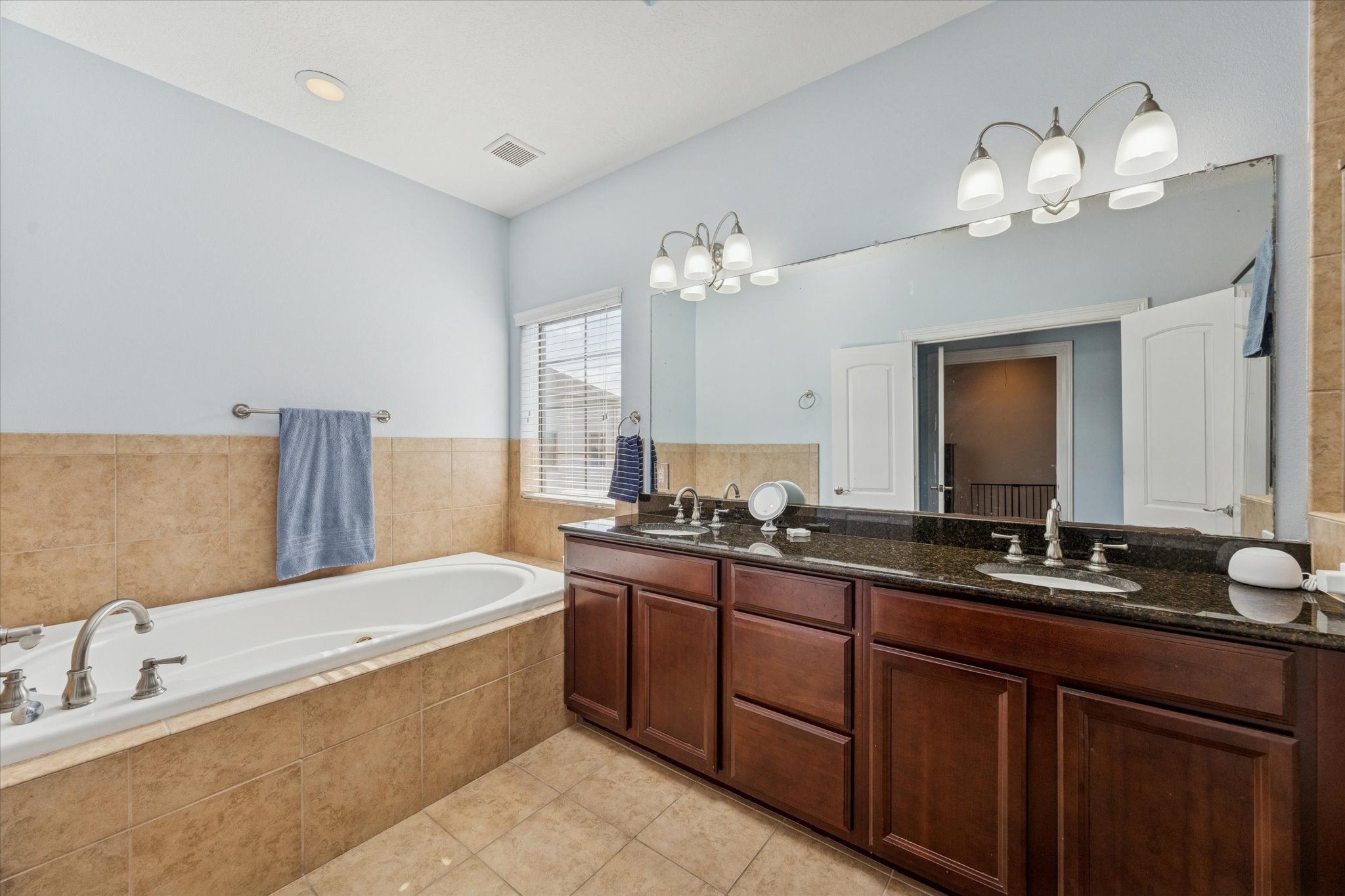 3203 Garden Oaks View Houston, TX 77018 - Photo 10 of 13 a spacious bathroom with a granite countertop sink a large mirror and a bathtub