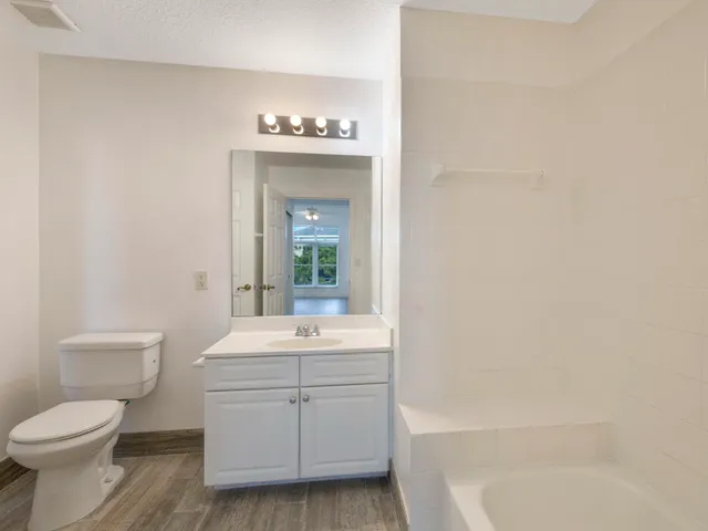 a bathroom with a sink a toilet and mirror