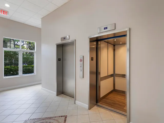 a view of a hallway with a glass door and furniture