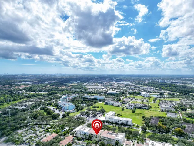 a front view of multi story residential apartment building with yard and green space