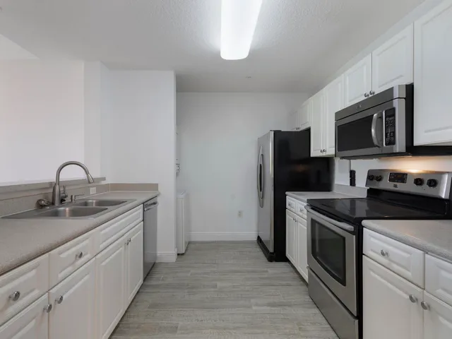 a kitchen with stainless steel appliances granite countertop a stove top oven a sink and dishwasher