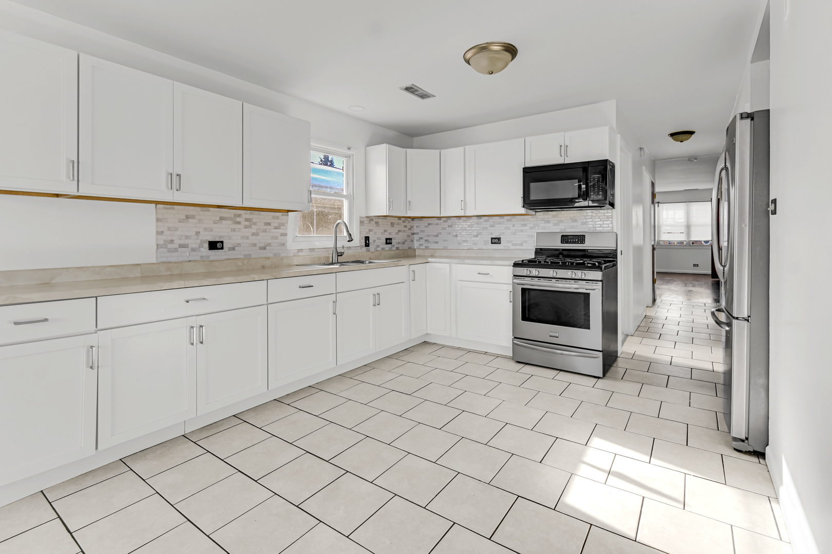 403 Prairie Avenue, Unit 1 Calumet City, IL 60409 - Photo 6 of 9 a kitchen with white cabinets a sink and white appliances