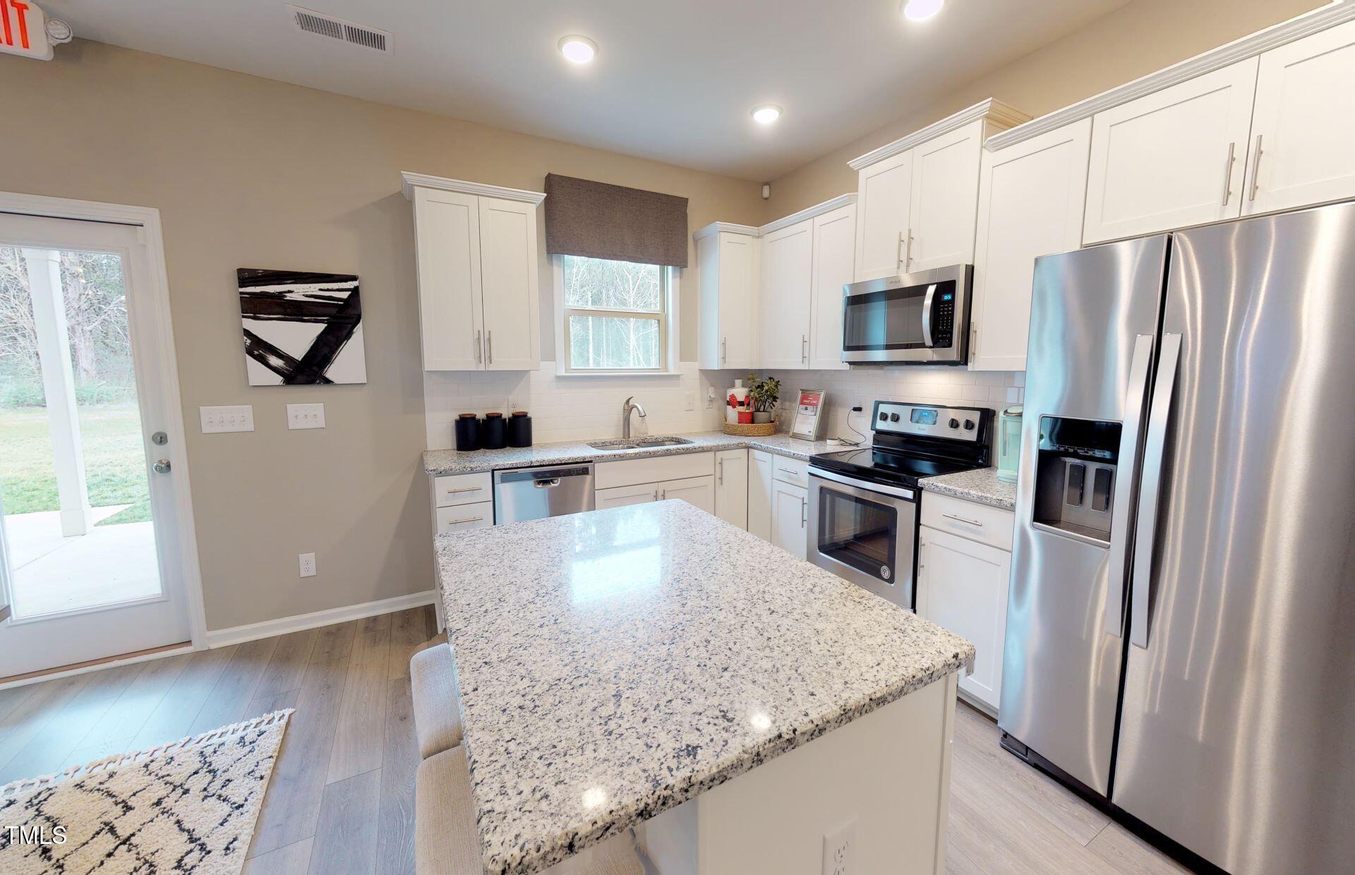 1105 Freestone Road Durham, NC 27703 - Photo 4 of 21 a kitchen with stainless steel appliances granite countertop a refrigerator a sink a stove a microwave and island