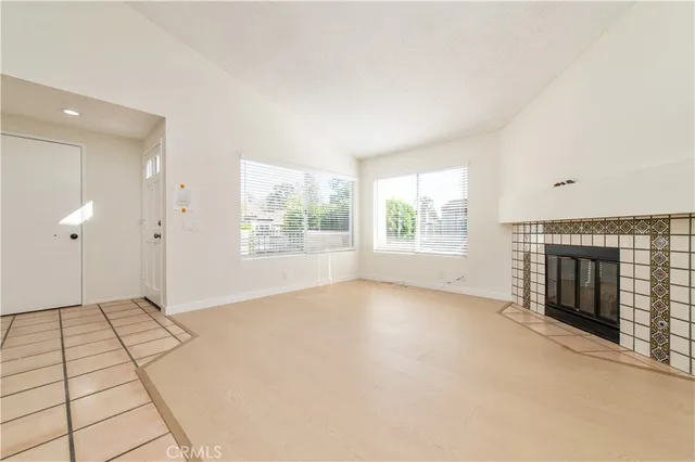 an empty room with windows and fireplace