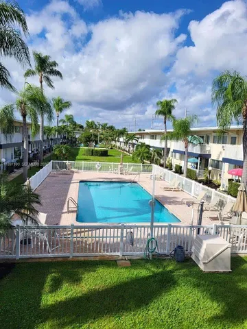 a view of a swimming pool with a patio and a garden