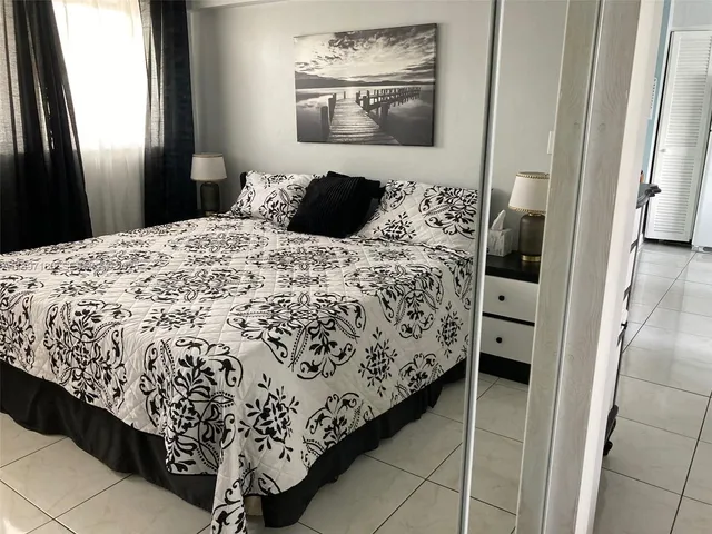 a bedroom with a bed and painting on the wall