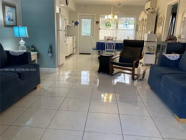 a living room with furniture a dining table and a chandelier