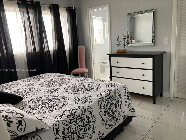 a bedroom with a bed and a mirror on dresser
