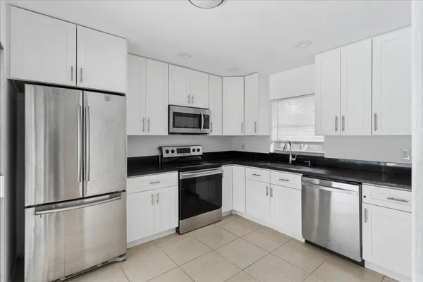 a kitchen with white cabinets and white appliances