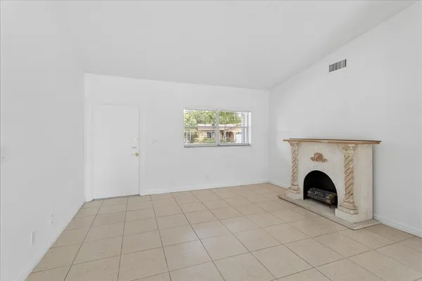 an empty room with fireplace and windows
