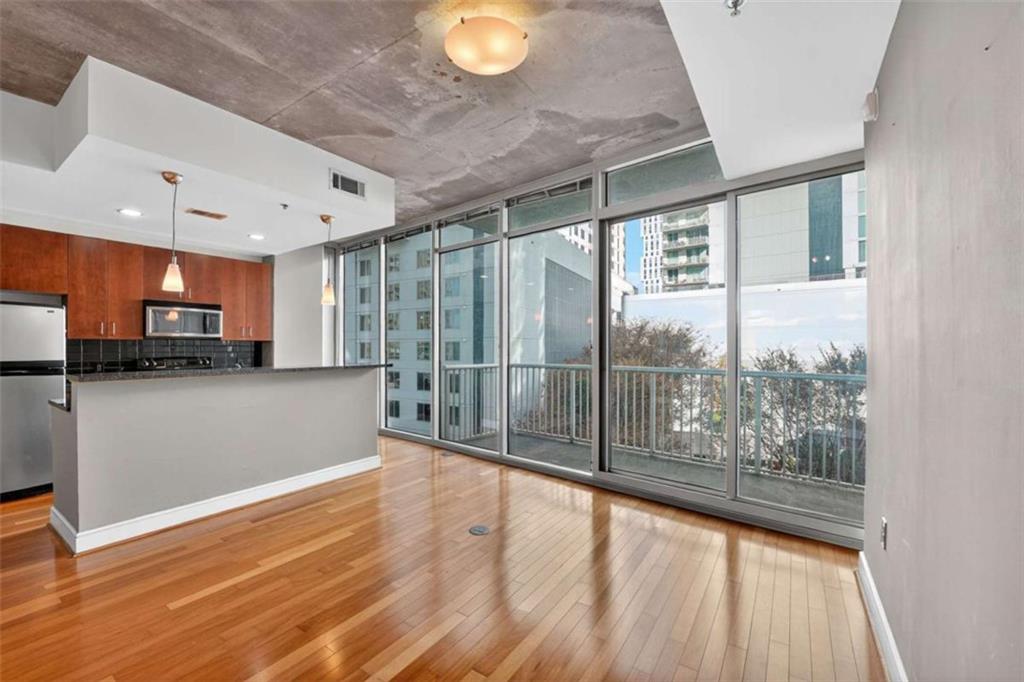 a view of a kitchen with stainless steel appliances wooden floor and a large window