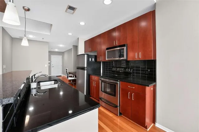 a kitchen with stainless steel appliances a stove a sink and a microwave