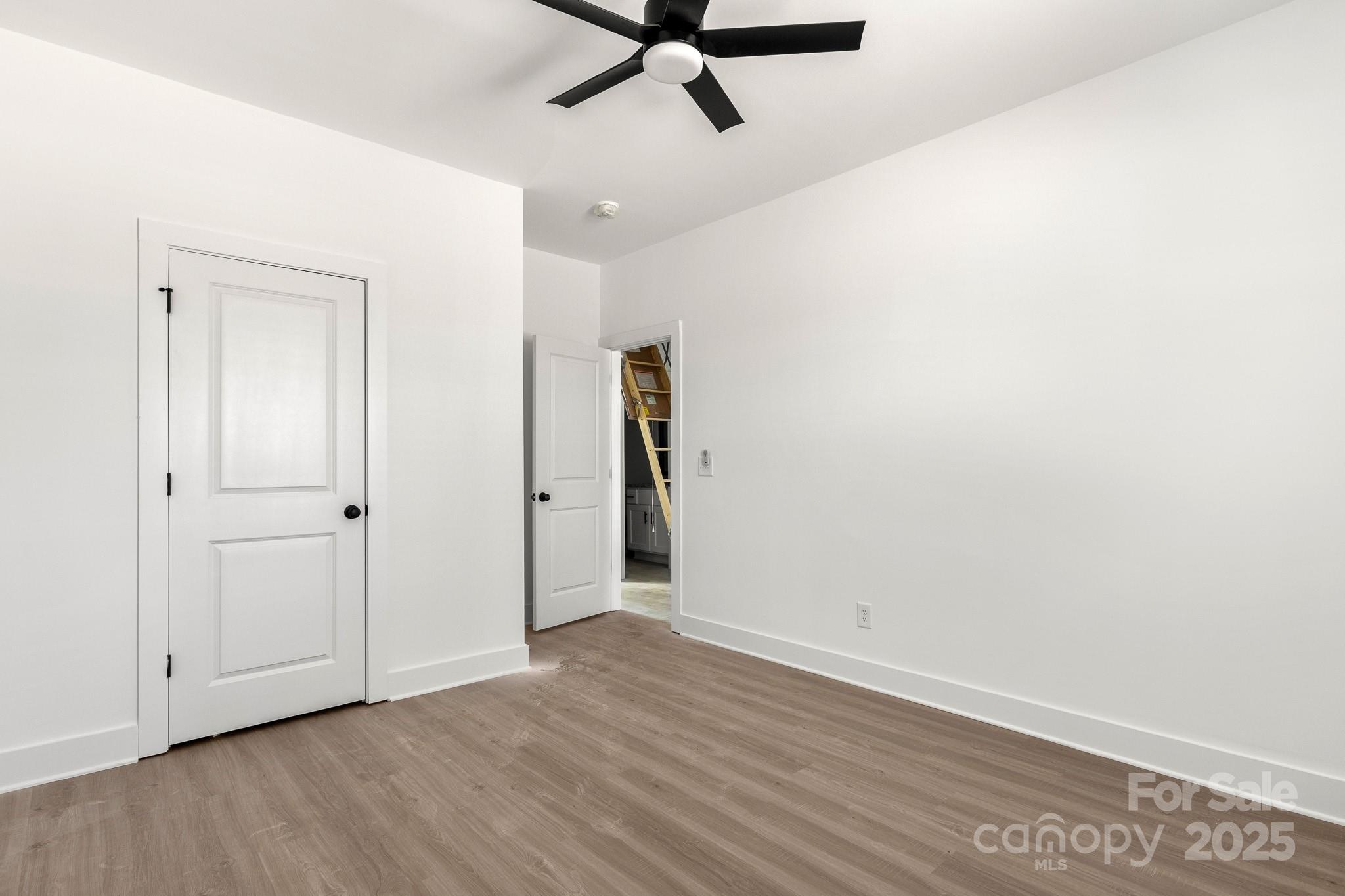 3307 Old Pageland Monroe Road Monroe, NC 28112 - Photo 23 of 35 an empty room with wooden floor and ceiling fan