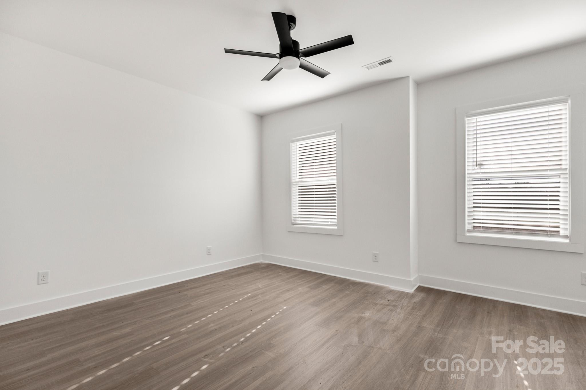 3307 Old Pageland Monroe Road Monroe, NC 28112 - Photo 25 of 35 an empty room with wooden floor ceiling fan and windows