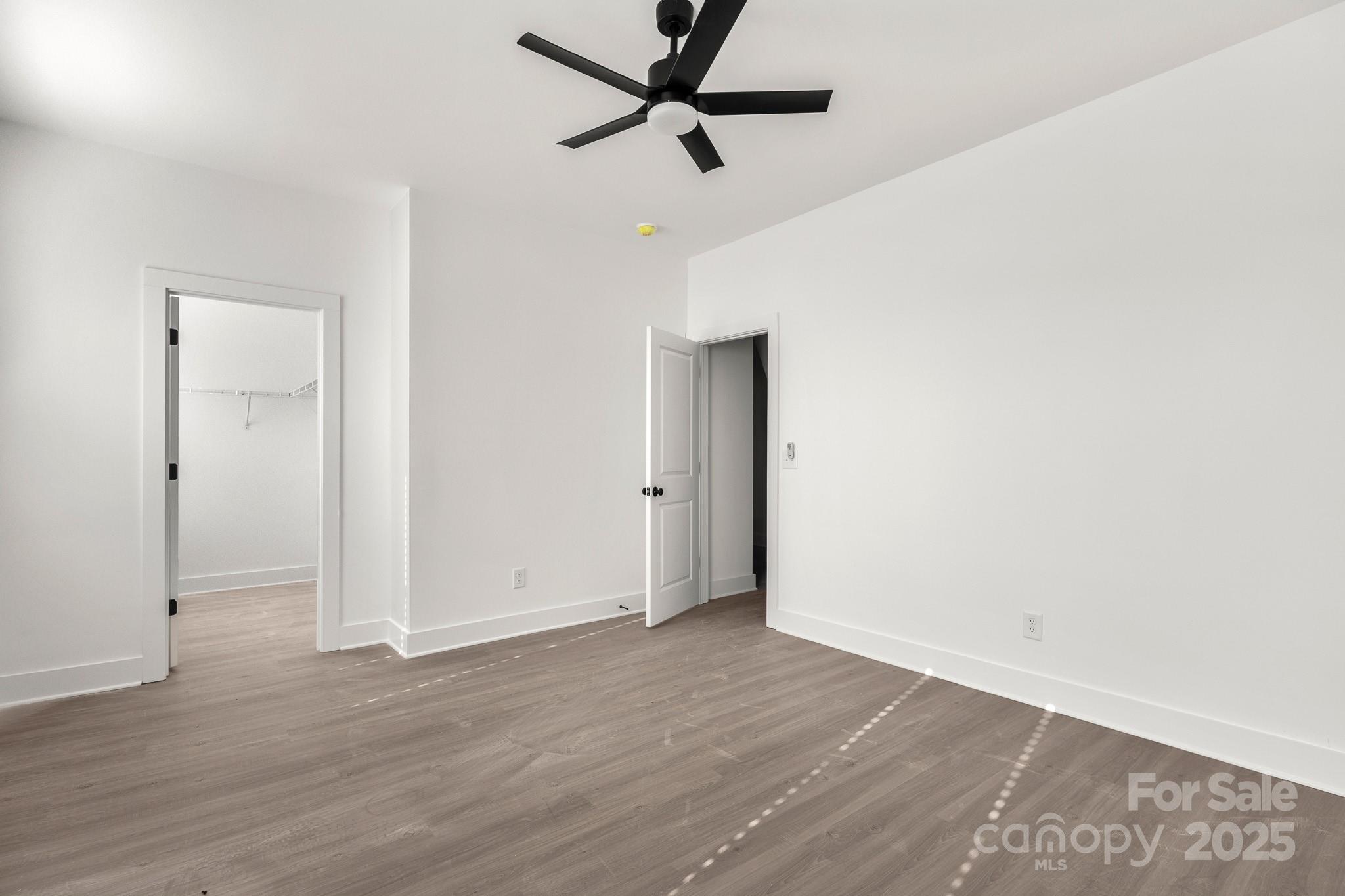 3307 Old Pageland Monroe Road Monroe, NC 28112 - Photo 27 of 35 an empty room with wooden floor and a ceiling fan