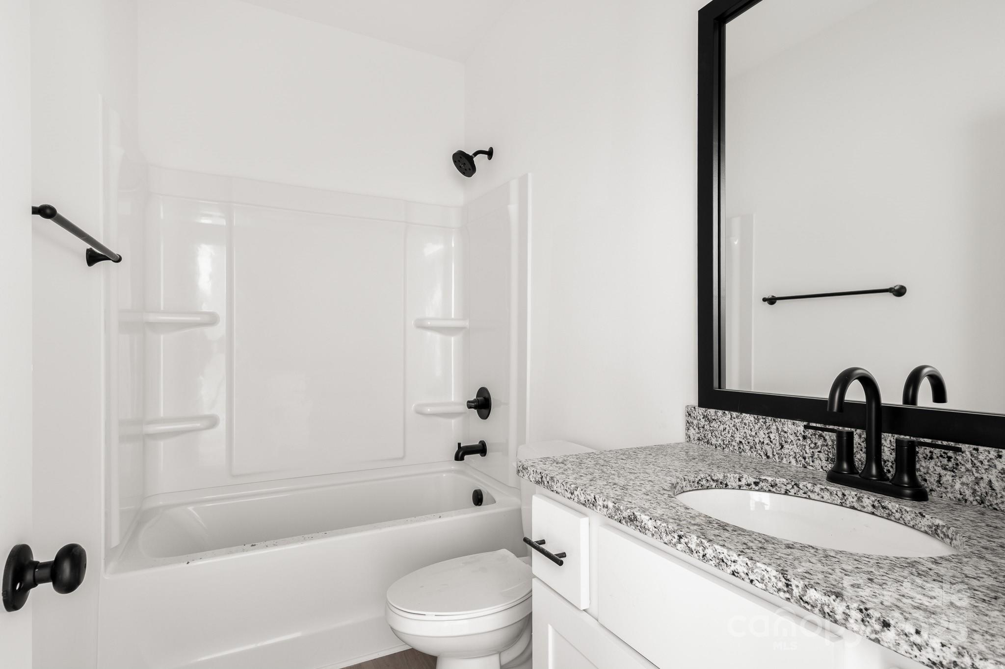3307 Old Pageland Monroe Road Monroe, NC 28112 - Photo 28 of 35 a bathroom with a granite countertop sink a toilet and shower