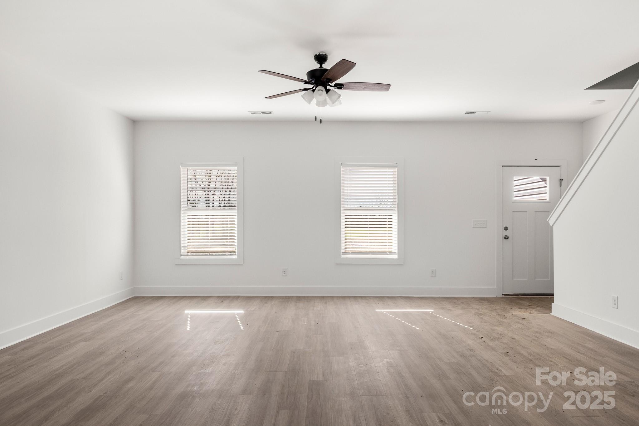 3307 Old Pageland Monroe Road Monroe, NC 28112 - Photo 3 of 35 an empty room with wooden floor fan and windows