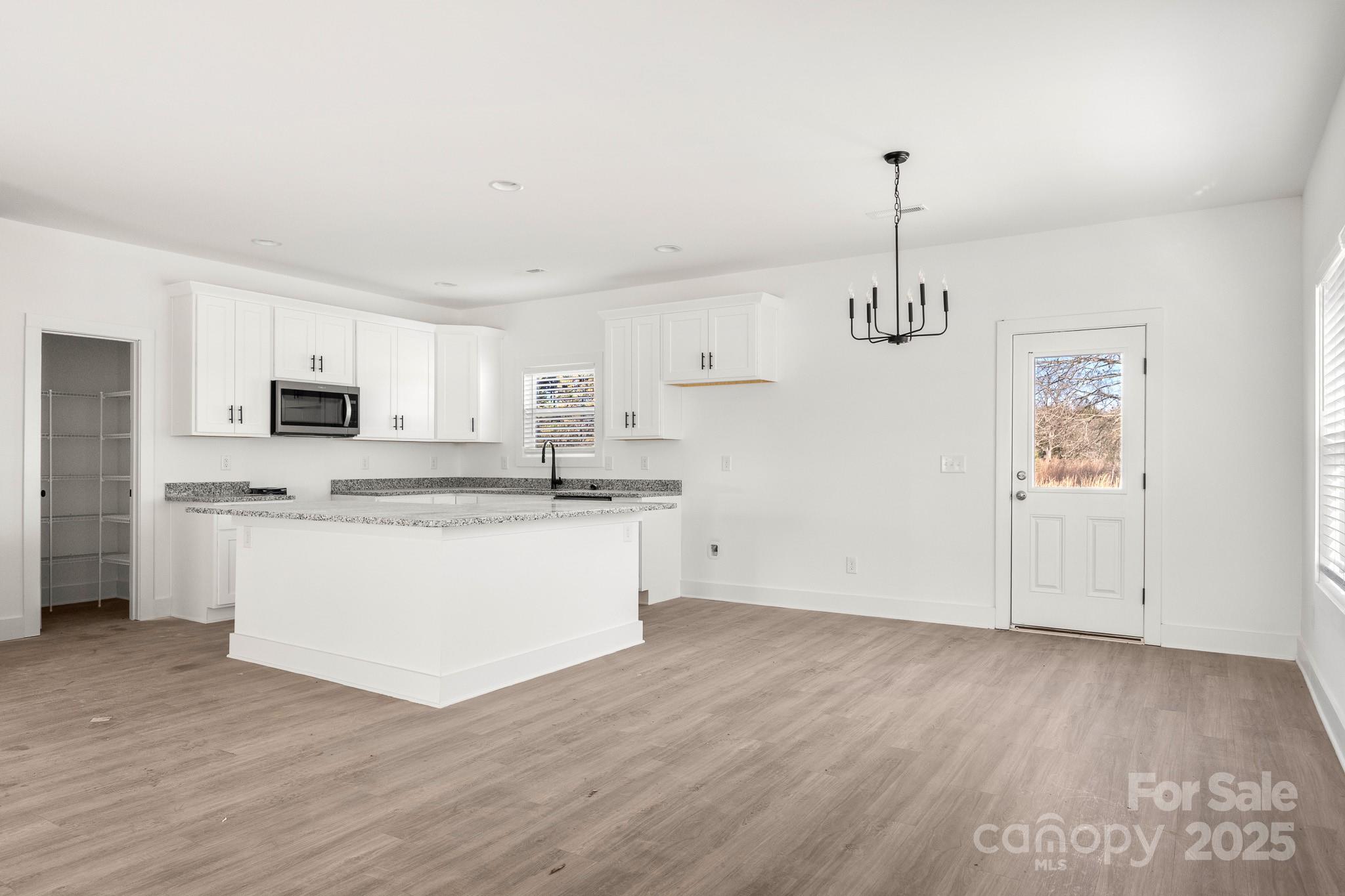 3307 Old Pageland Monroe Road Monroe, NC 28112 - Photo 6 of 35 a kitchen with stainless steel appliances granite countertop a sink a stove a refrigerator and white cabinets with wooden floor