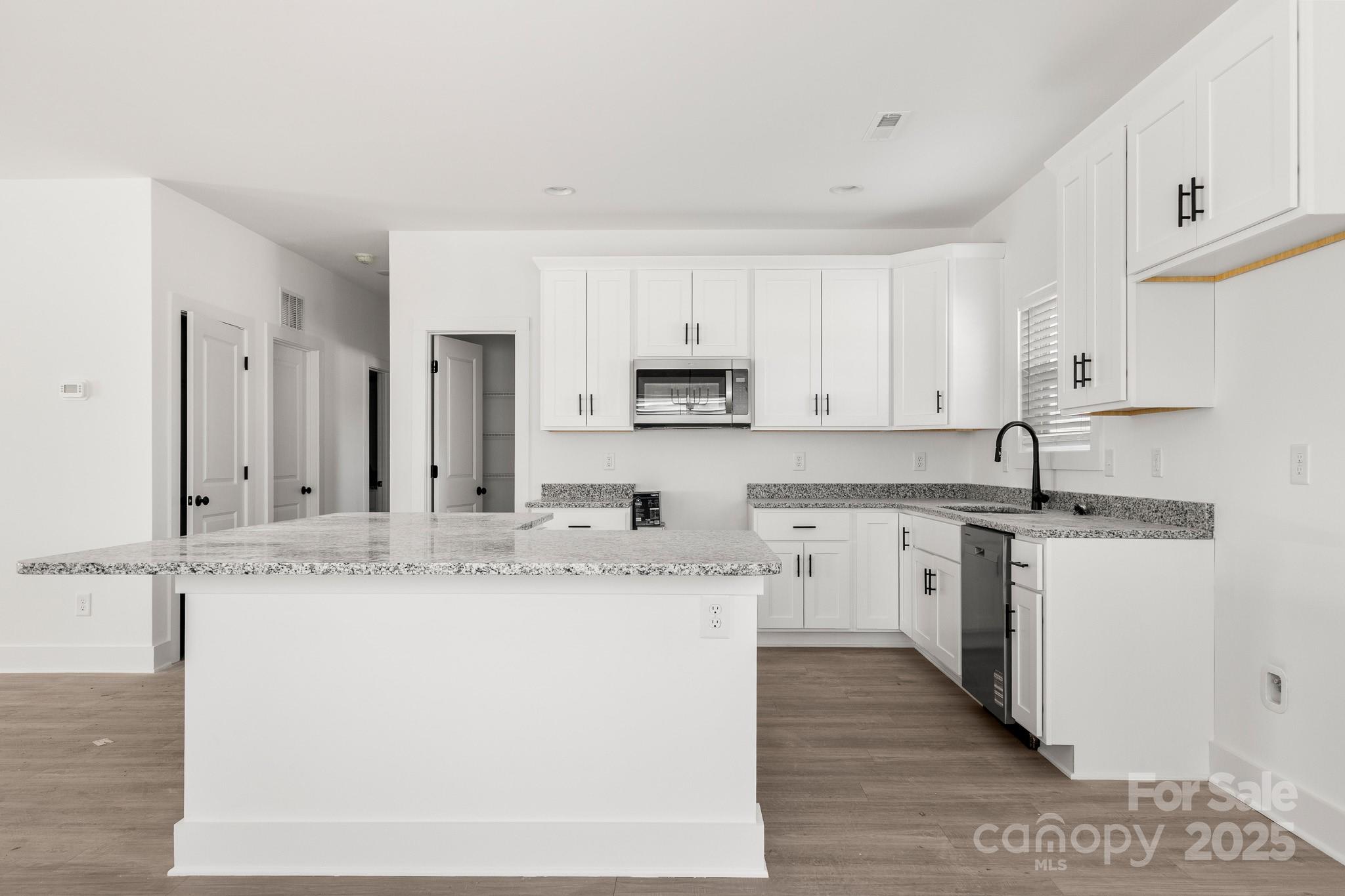 3307 Old Pageland Monroe Road Monroe, NC 28112 - Photo 9 of 35 a kitchen with stainless steel appliances granite countertop a sink and cabinets with wooden floor