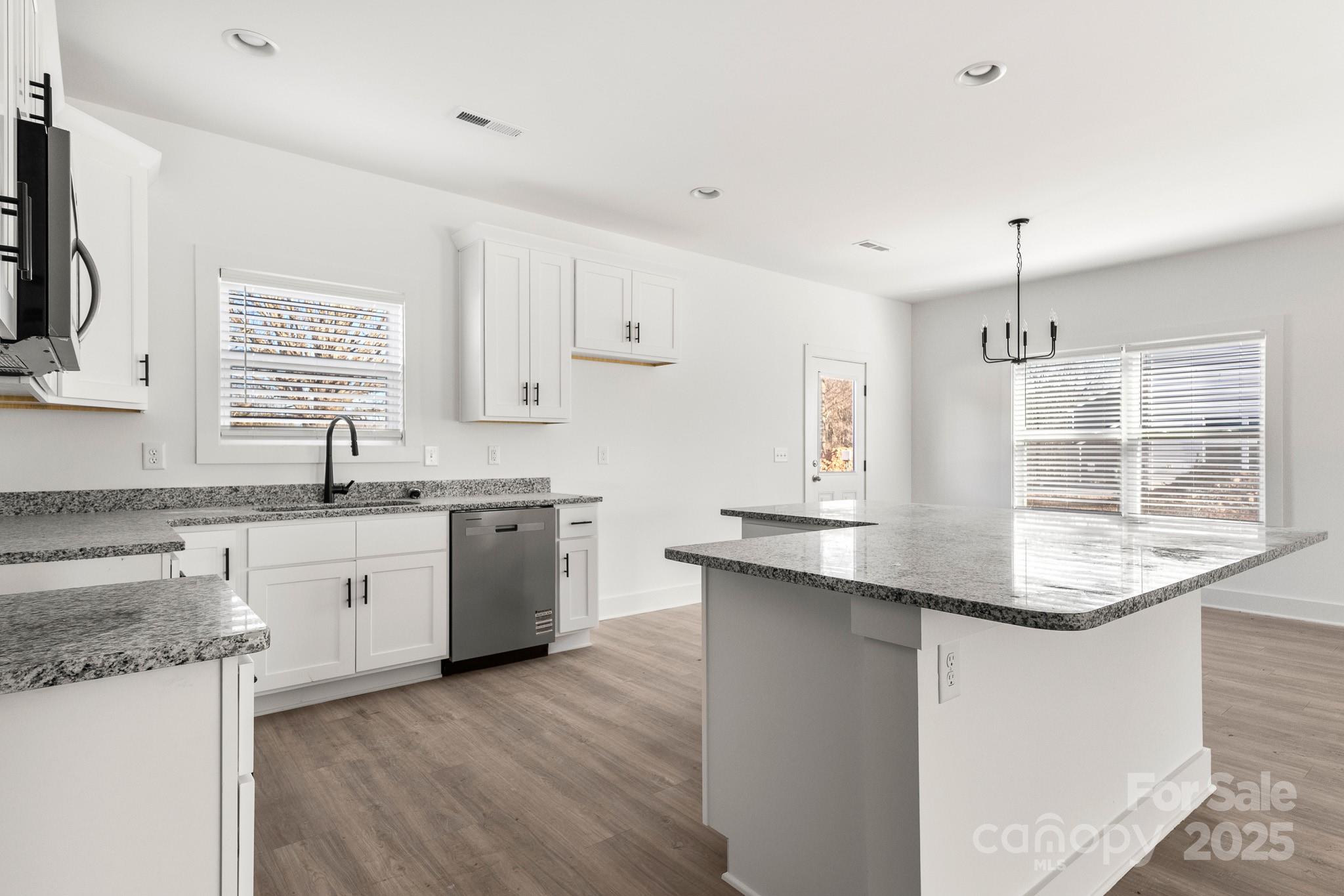 3307 Old Pageland Monroe Road Monroe, NC 28112 - Photo 10 of 35 a kitchen with kitchen island granite countertop a sink cabinets and wooden floor