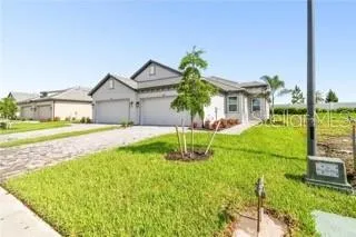 a house with green field in front of it