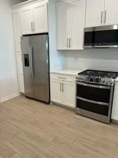 a kitchen with granite countertop a stove and a microwave
