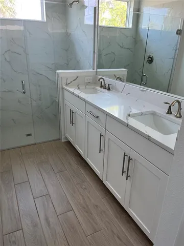 a bathroom with a double vanity sink and mirror