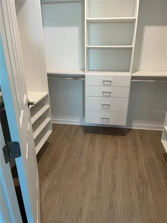 a view of walk in closet with empty racks