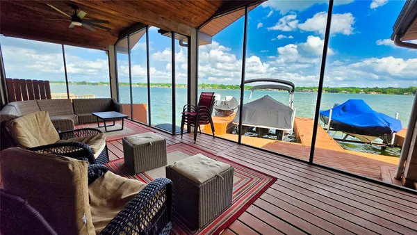 a living room with furniture a floor to ceiling window and wooden floor