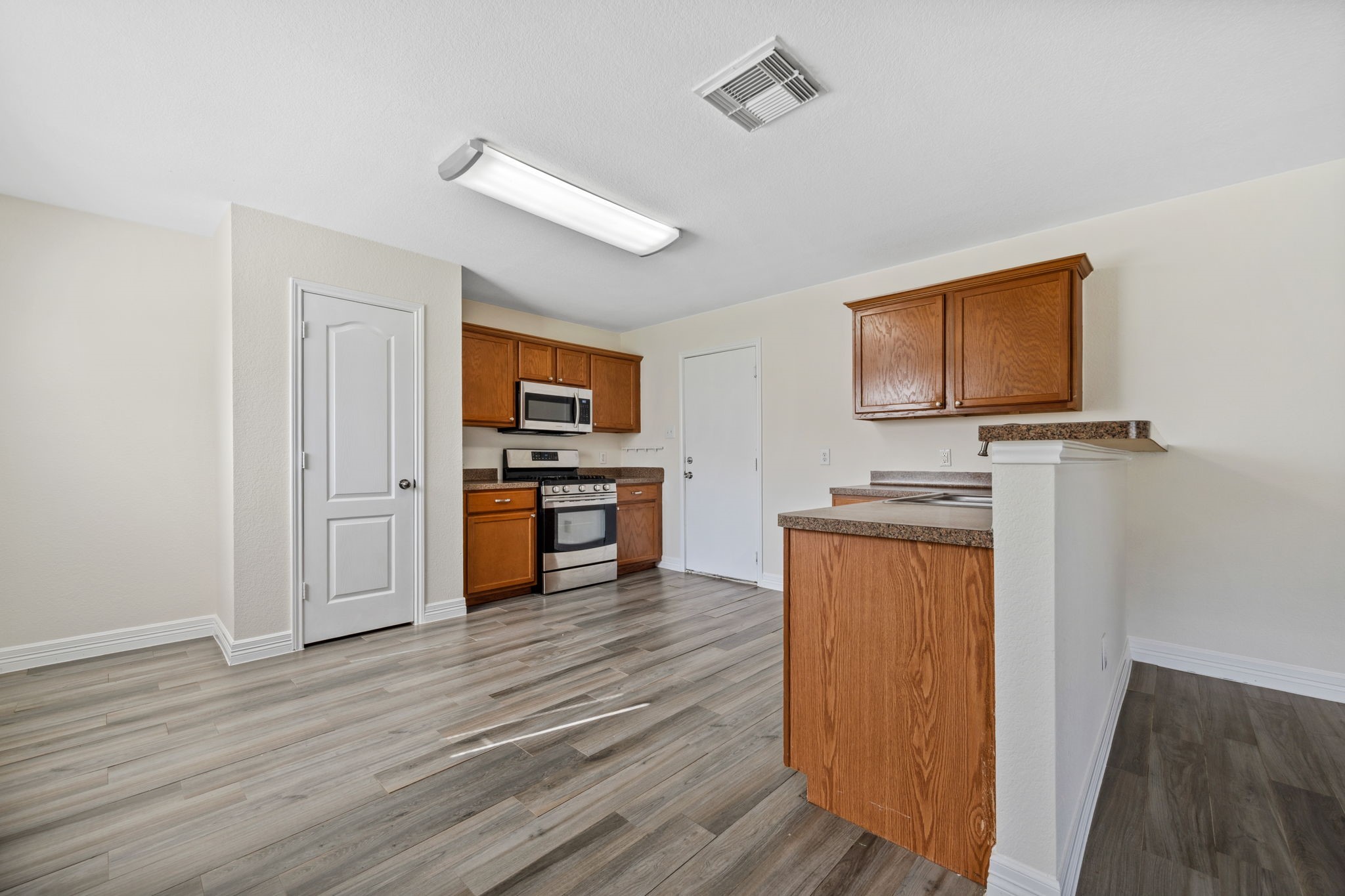 12819 Blue Timbers Court Houston, TX 77044 - Photo 11 of 26 a view of a kitchen with wooden floor and electronic appliances