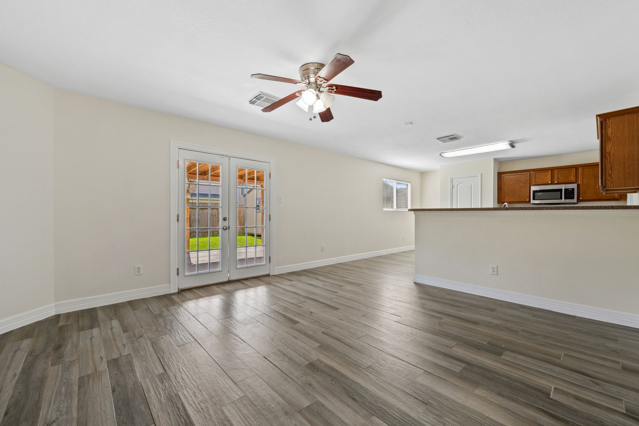 12819 Blue Timbers Court Houston, TX 77044 - Photo 7 of 26 a view of a kitchen with wooden floor and a ceiling fan