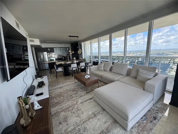 a living room with furniture large window and a flat screen tv