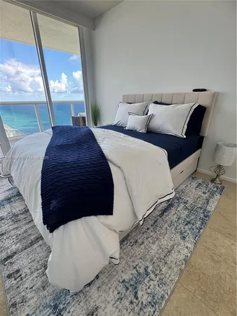 a large bed sitting in a bedroom next to a window