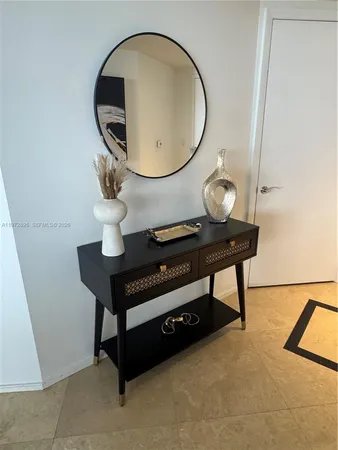 a living room with furniture a mirror and a potted plant