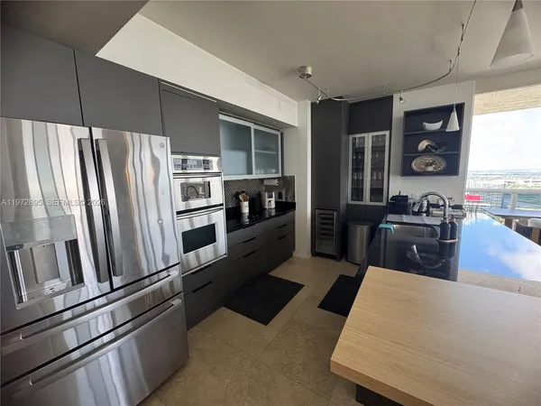a kitchen with stainless steel appliances granite countertop a refrigerator and a stove